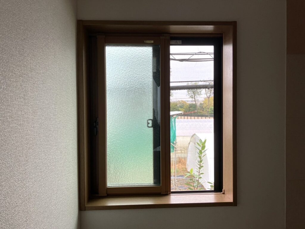 型板ガラスの2枚建て引違い窓が付いています。