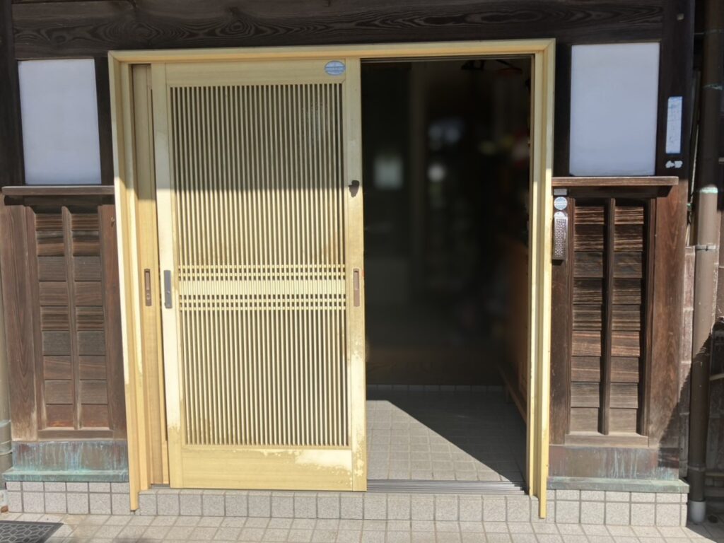経年変化により木部の傷みや塗装の剥がれが見られた従来の玄関引戸。<br />
さらに開閉の際、動きが悪いのがお悩みでした。